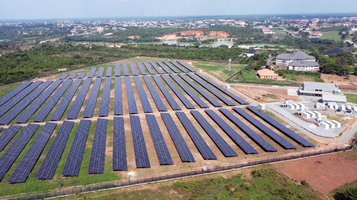 A commissioned solar array seen from the air, next to the community it supplies